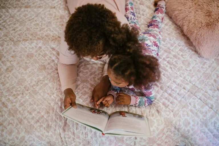 A mother and daughter enjoying storytime on a cozy bed, fostering bonding and togetherness.