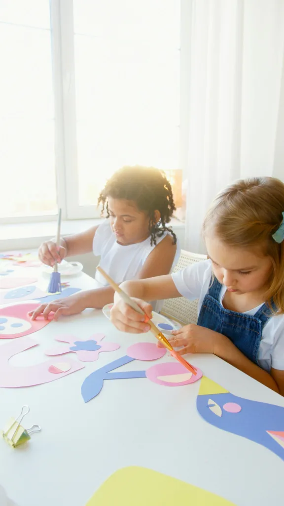 Children enjoying painting art projects with bright colors indoors.