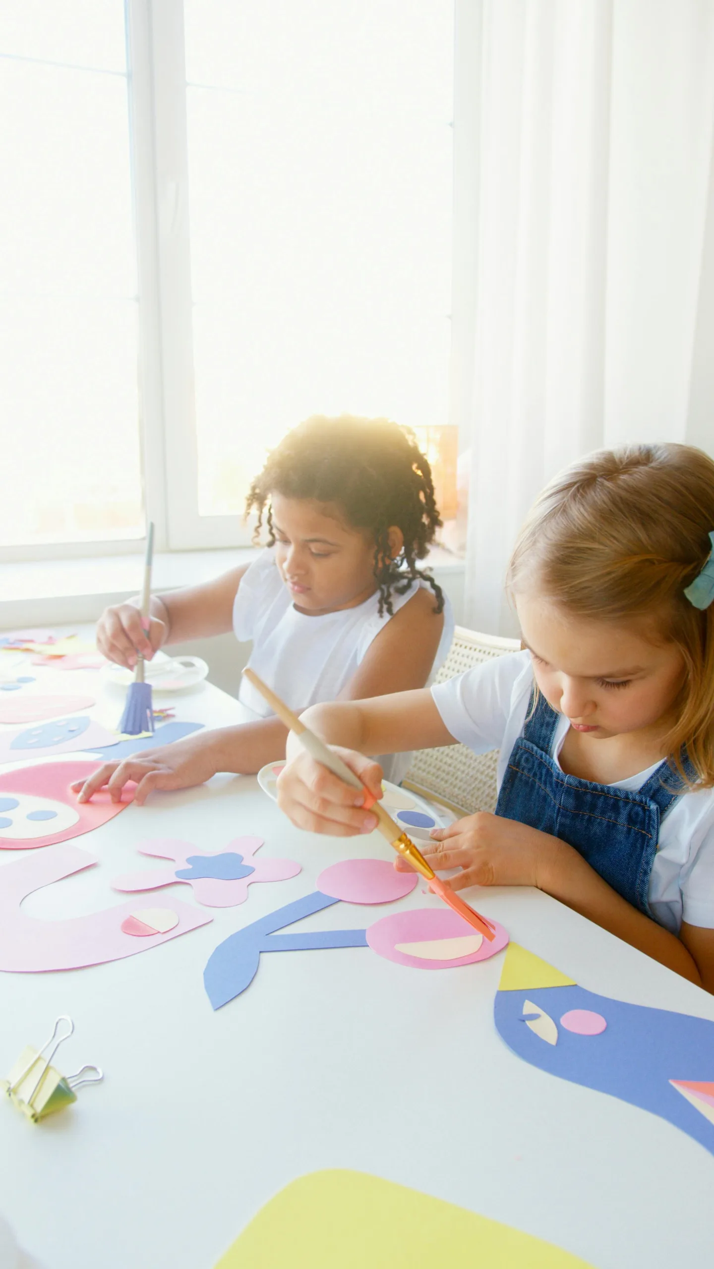 Children enjoying painting art projects with bright colors indoors.